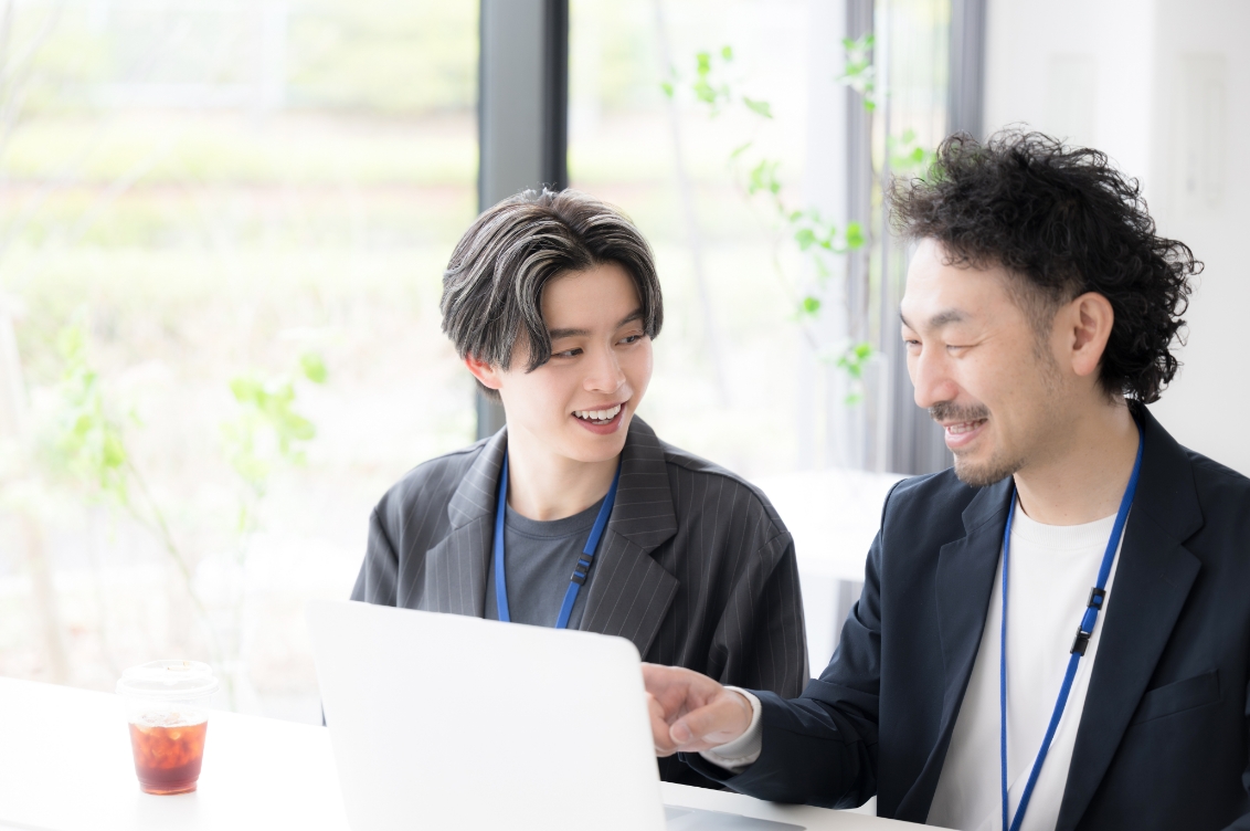 パソコンを見ながら会話する社員の様子
